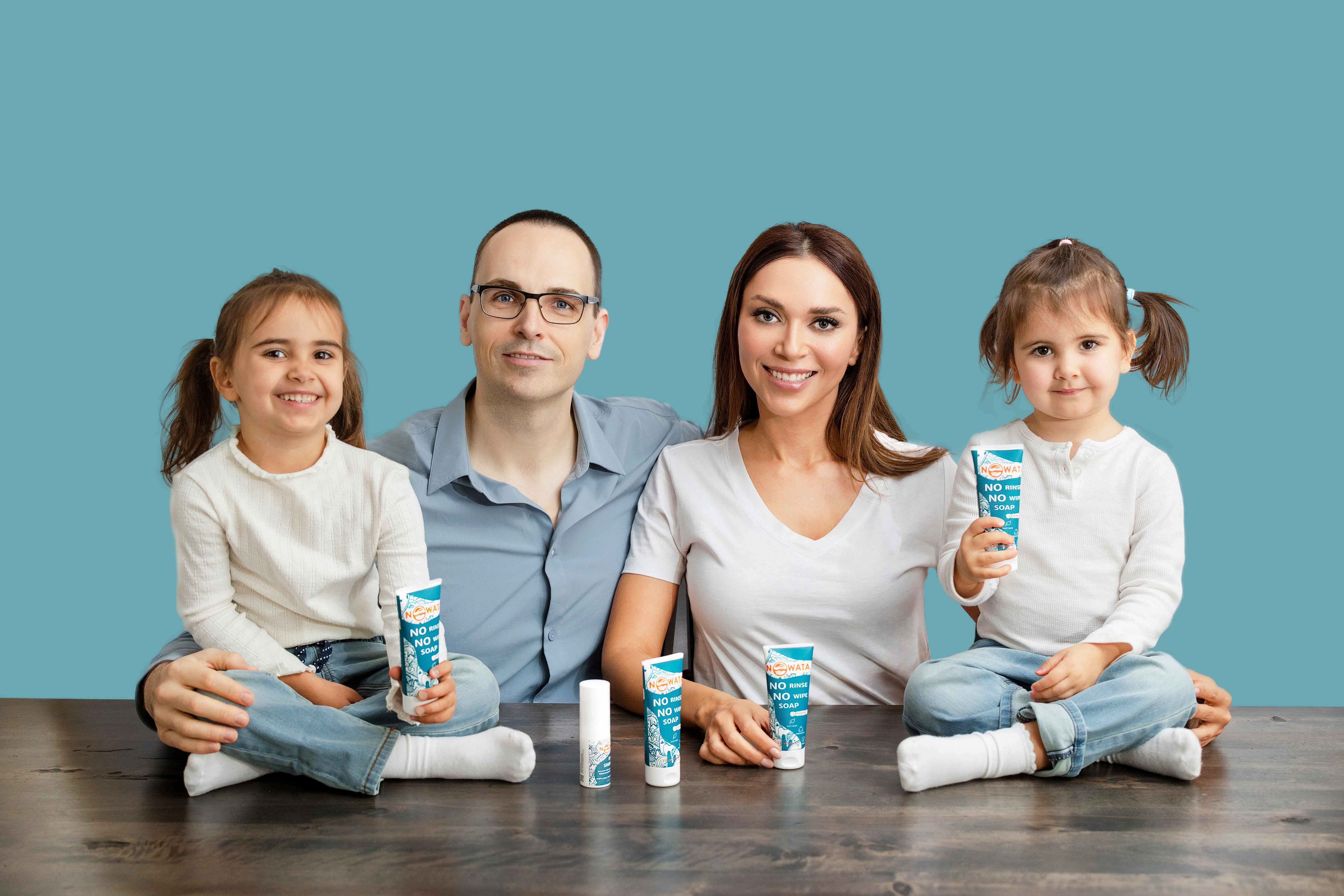 Founder family with two young children holding NOWATA tubes—kid-safe sanitizer alternative; plant-based rinse-free soap that physically removes 99% of germs, no water needed. Ruslan Maidans and Yalda Shahriari