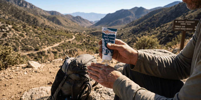 An image of a hiker using NOWATA plant-based, rinse-free soap to clean their hands on a backcountry trail, illustrating no-water hand hygiene that leaves no trace where sinks and clean water aren't available.