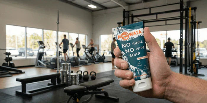 An image of NOWATA No Rinse Soap being held in a busy gym setting.