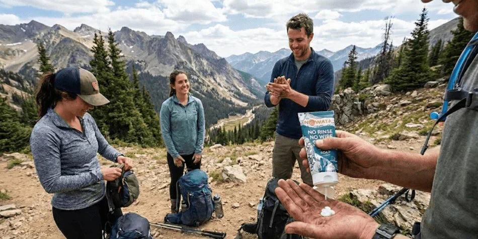 View of hikers dispense Nowata No Rinse No Wipe soap onto their palm for hand and hygiene and infection control while on a mountain trail with a group of friends, where water is not readily available.