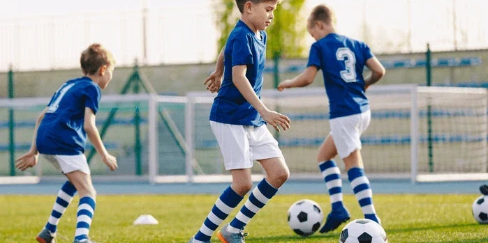 An image of youth soccer players at practice on a field.
