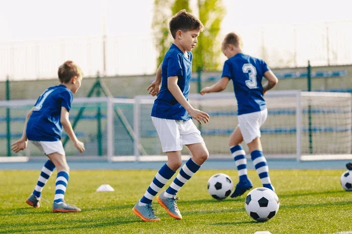 An image of youth soccer players at practice on a field.