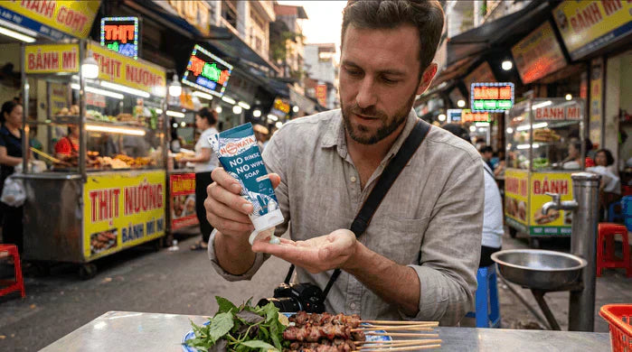 An image of a traveler using NOWATA plant-based no-rinse soap before eating street food abroad, illustrating hand hygiene to help prevent traveler's diarrhea when clean water isn't available.
