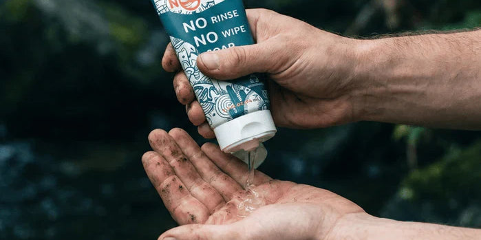 an image of hands applying Nowata rinse-free soap outdoors, demonstrating effective hand hygiene alternatives for families when traditional sinks are unavailable.