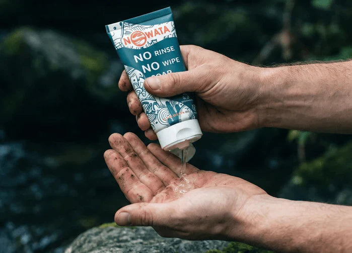 an image of hands applying Nowata rinse-free soap outdoors, demonstrating effective hand hygiene alternatives for families when traditional sinks are unavailable.